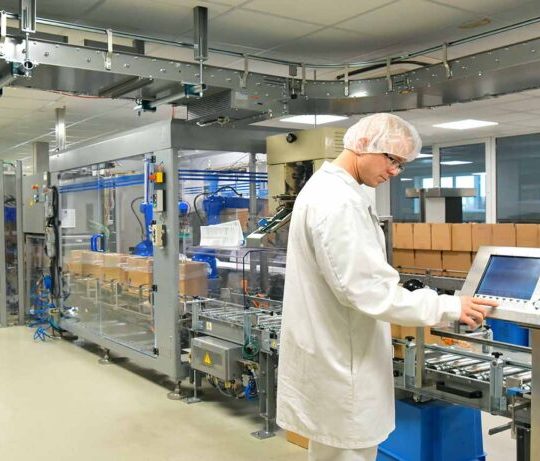 Arbeiter in Schutzkleidung am Fliessband für den Versand Pakete